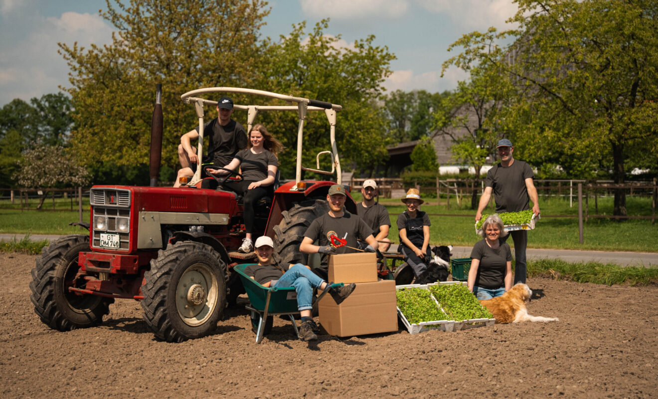 Die ganze Familie mit Traktor und Sellerie auf dem Feld
